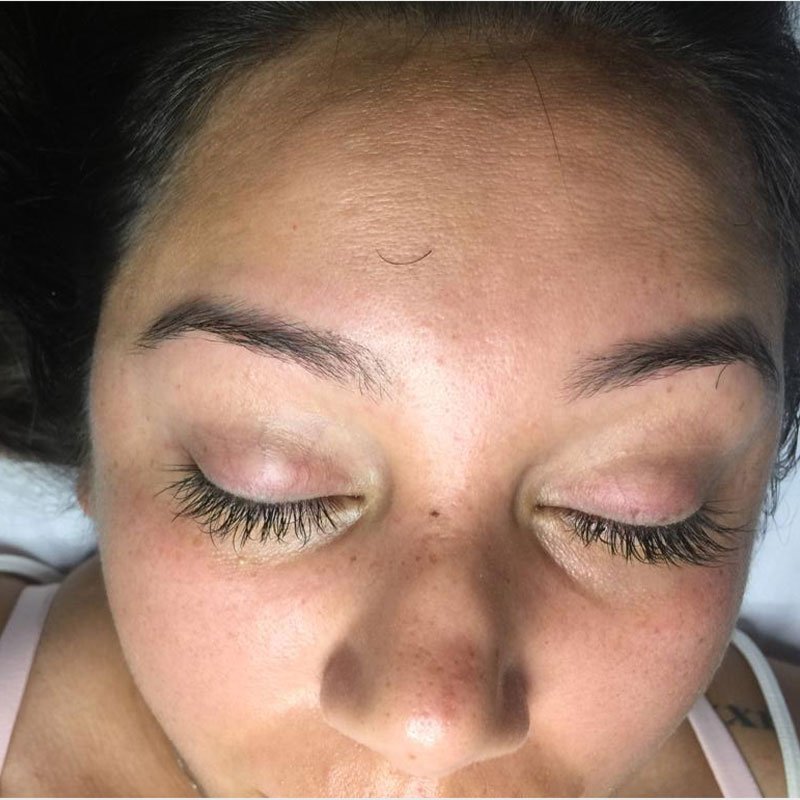 Close-up of precisely shaped brows and long lashes after threading.